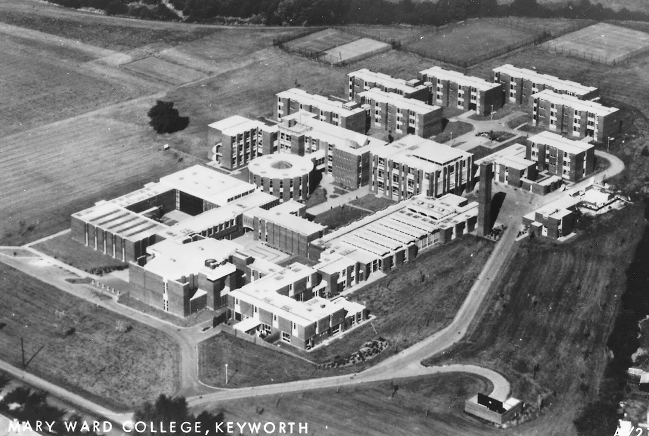 Black and white aerial photograph of Mary Ward College in Keyworth in 1975: flat-roofed college blocks of two to four storeys around courtyards, a circular building and a tall tower, with a road curving past and fields beyond.